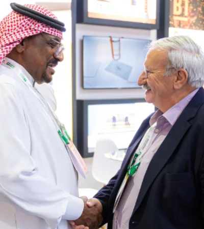 مصافحة بين مشاركين خلال لقاء عمل في أحد أجنحة المعرض